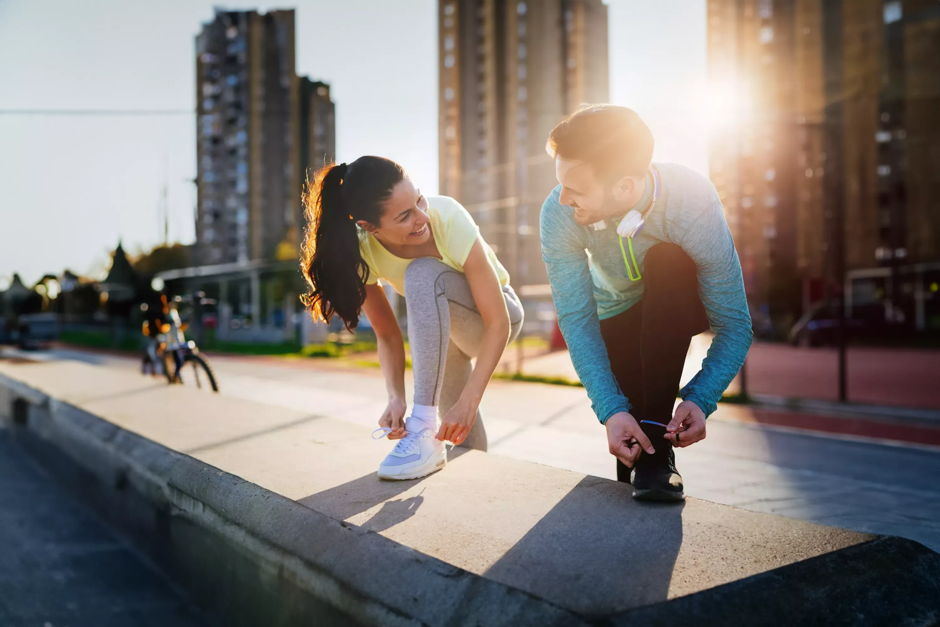 Sport & Fitness Man und Frau die Schuhe zubinden als Vorbereitung fürs joggen